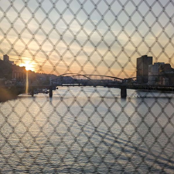 The sun setting over a bridge and a river in Pittsburgh