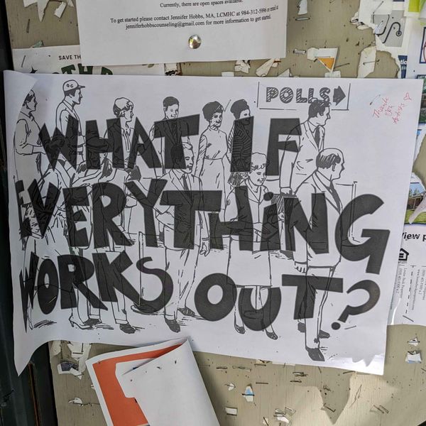 A sign on a bulletin board that says What if Everything Works Out and shows people going to the polls to vote