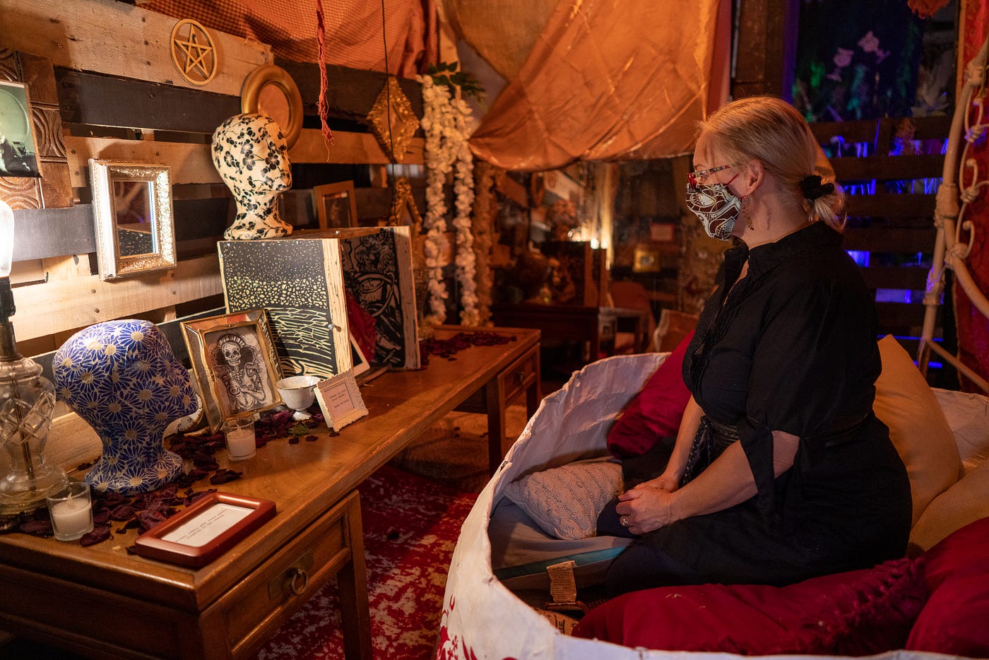 a womxn sitting in pillows looking into a box