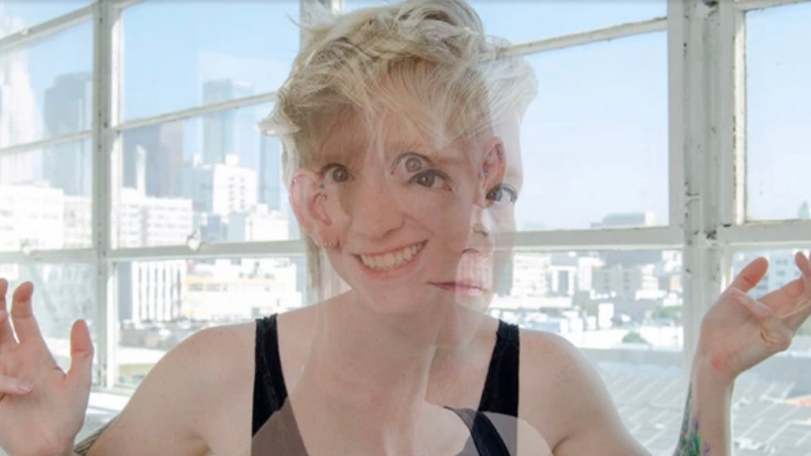 A white woman with short, platinum hair stands in front of a window. Behind her is the view of a city skyline. Two images of the woman overlap each other: In one, she’s smiling, and in the other her expression is dulled and serious.