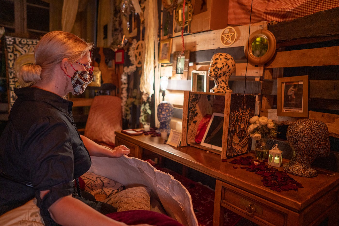 a womxn sitting on pillows looking into a box with an iPad