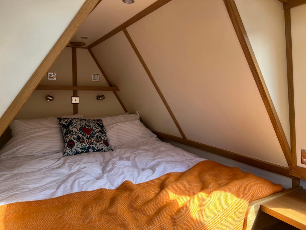 Photo by Author — a double bed in an old style bow of a narrowboat
