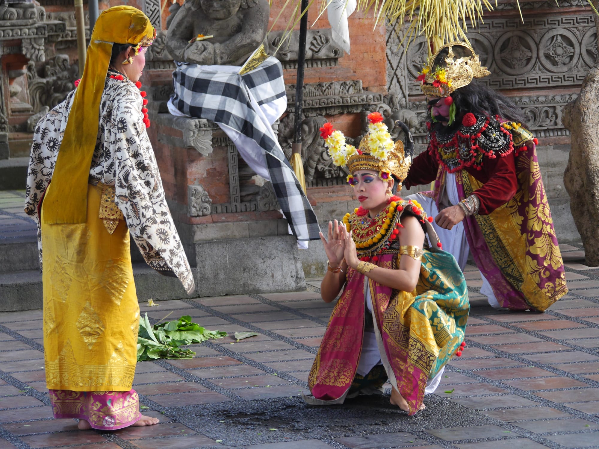 Photo by Author — Dewi Kunti (standing with their back to the camera) and their son, Sahadewa (kneeling)? — Sahadewa Barong and Kris Dance, Bali, Indonesia