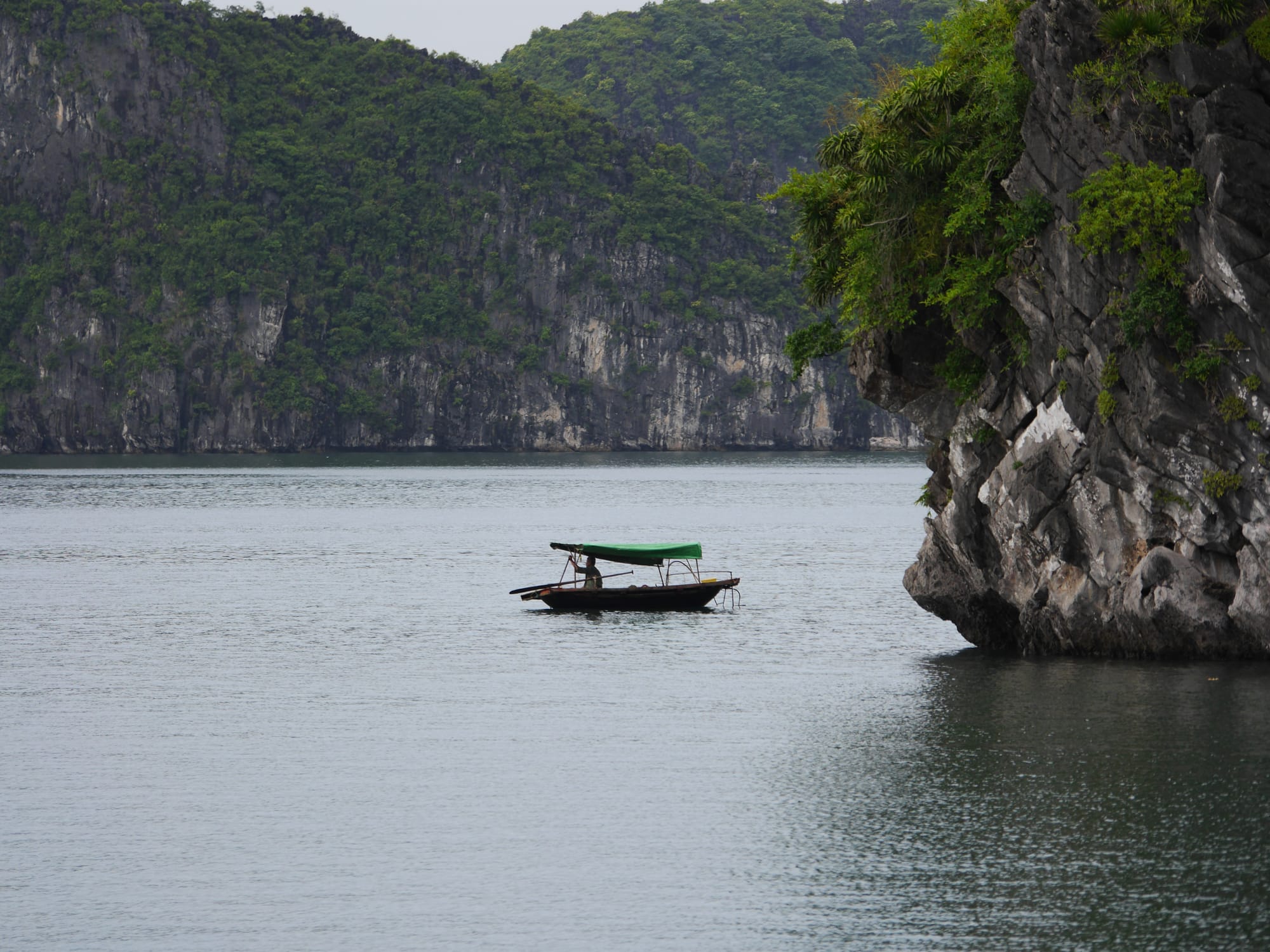 Photo by Author — a local in a boat — Ha Long Bay, Vietnam