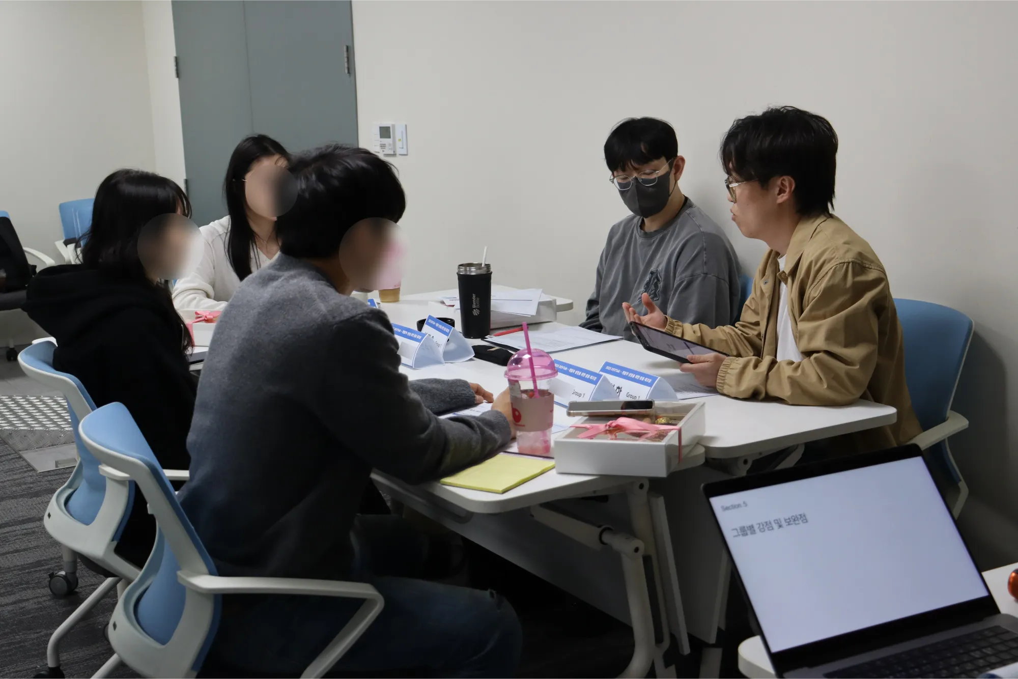 그룹별로 앉아 있는 참가자들에게 디브리핑 연사님이 결과 분석 및 피드백 하는 모습