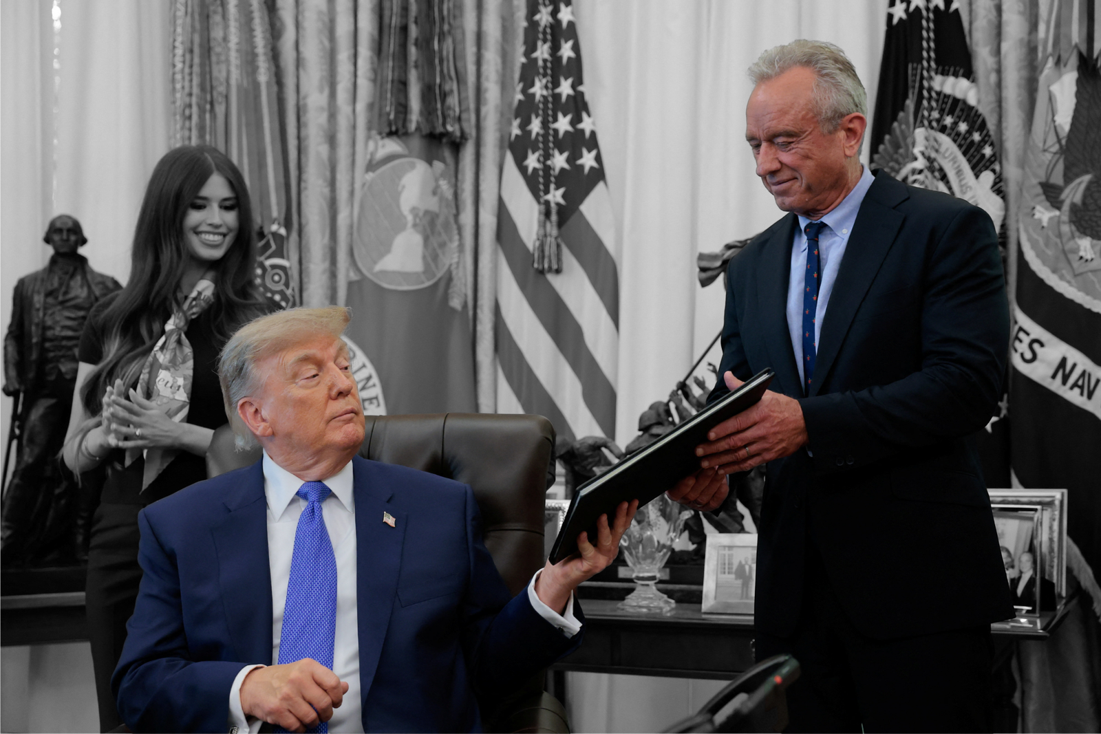 President Donald Trump hands a signed executive order on vaccines to HHS Secretary Robert F. Kennedy Jr.