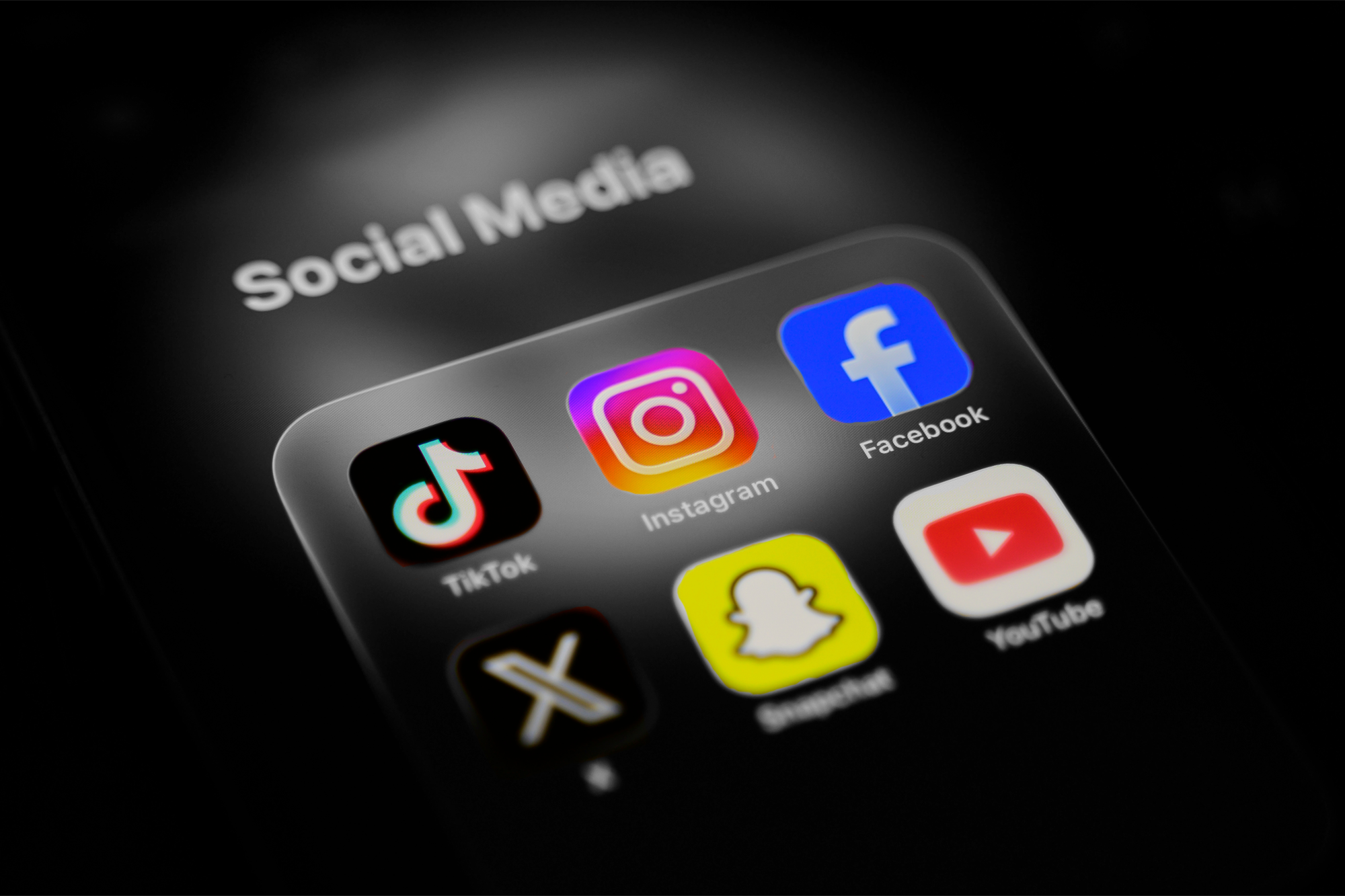 A smartphone displays a folder of social media applications | Samuel Boivin/NurPhoto, edited by Russell Nystrom
