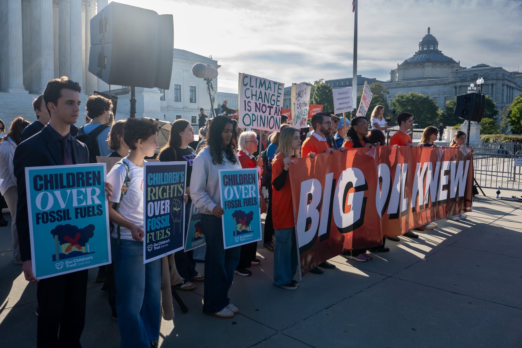 Environmental activists demonstrate in front of the Supreme Court as it hears oral arguments in Suncor v. Boulder