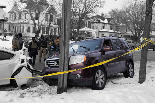 Federal agents next to a vehicle after its driver was shot by a U.S. immigration agent in Minneapolis, Minnesota | REUTERS/Tim Evans, edited by Russell Nystrom