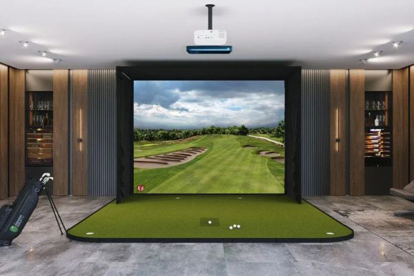Home golf simulator setup with hitting mat, impact screen and projector