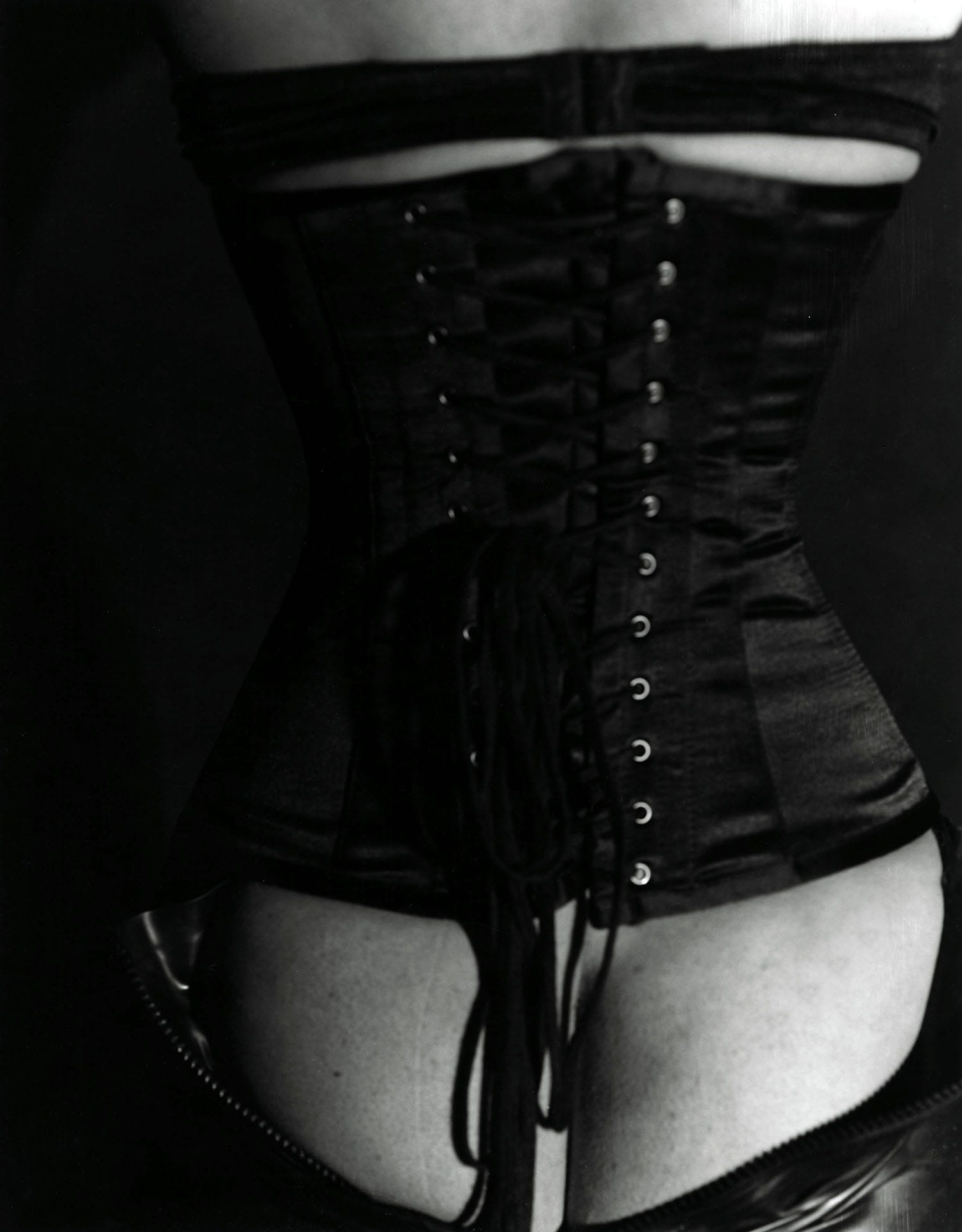 Black-and-white photo of a corseted torso, taken with consent.