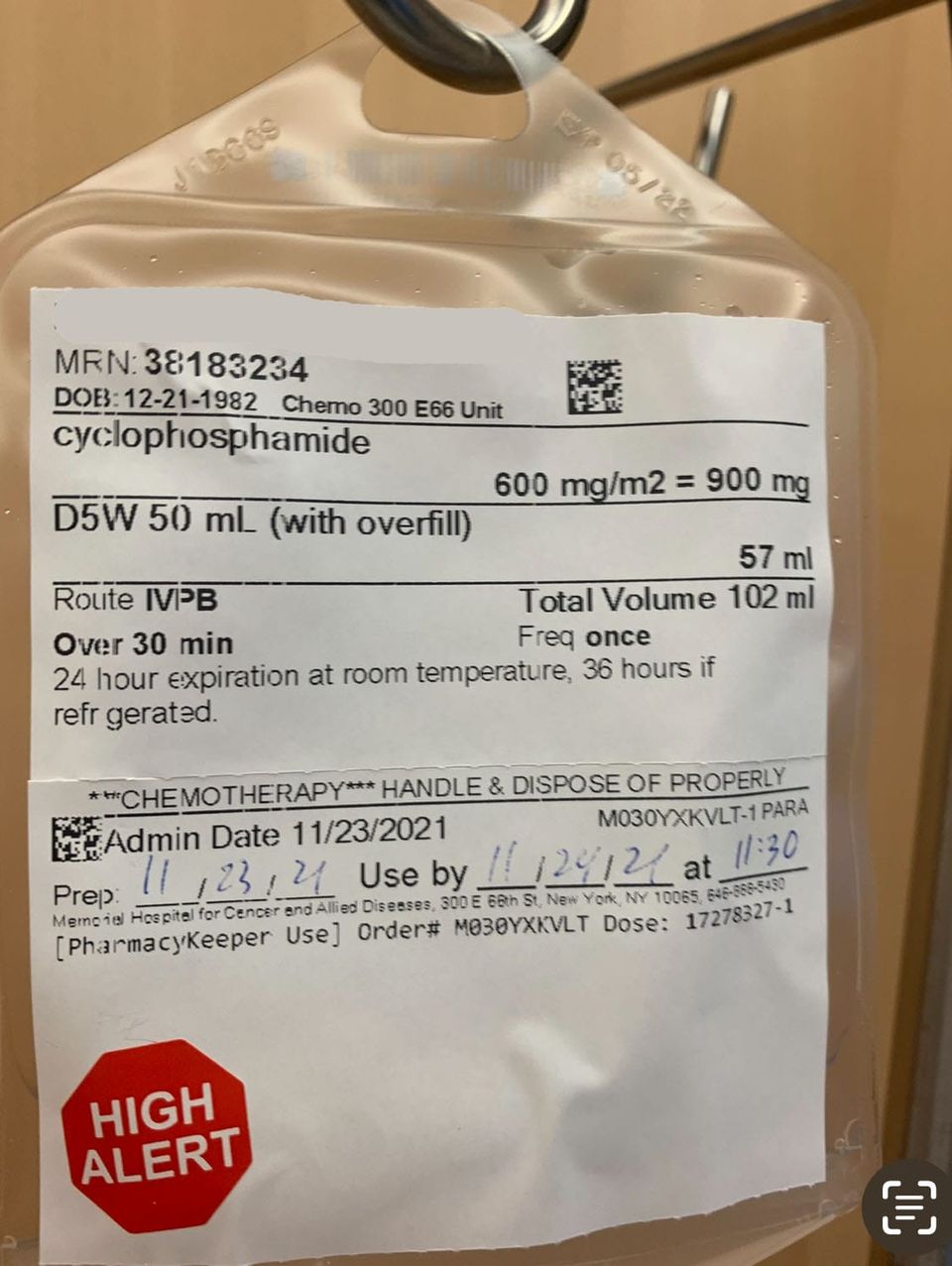 A chemotherapy IV bag labeled “cyclophosphamide,” hanging from a hospital hook. A red “HIGH ALERT” sticker marks it. A document of survival, treatment, and cost.