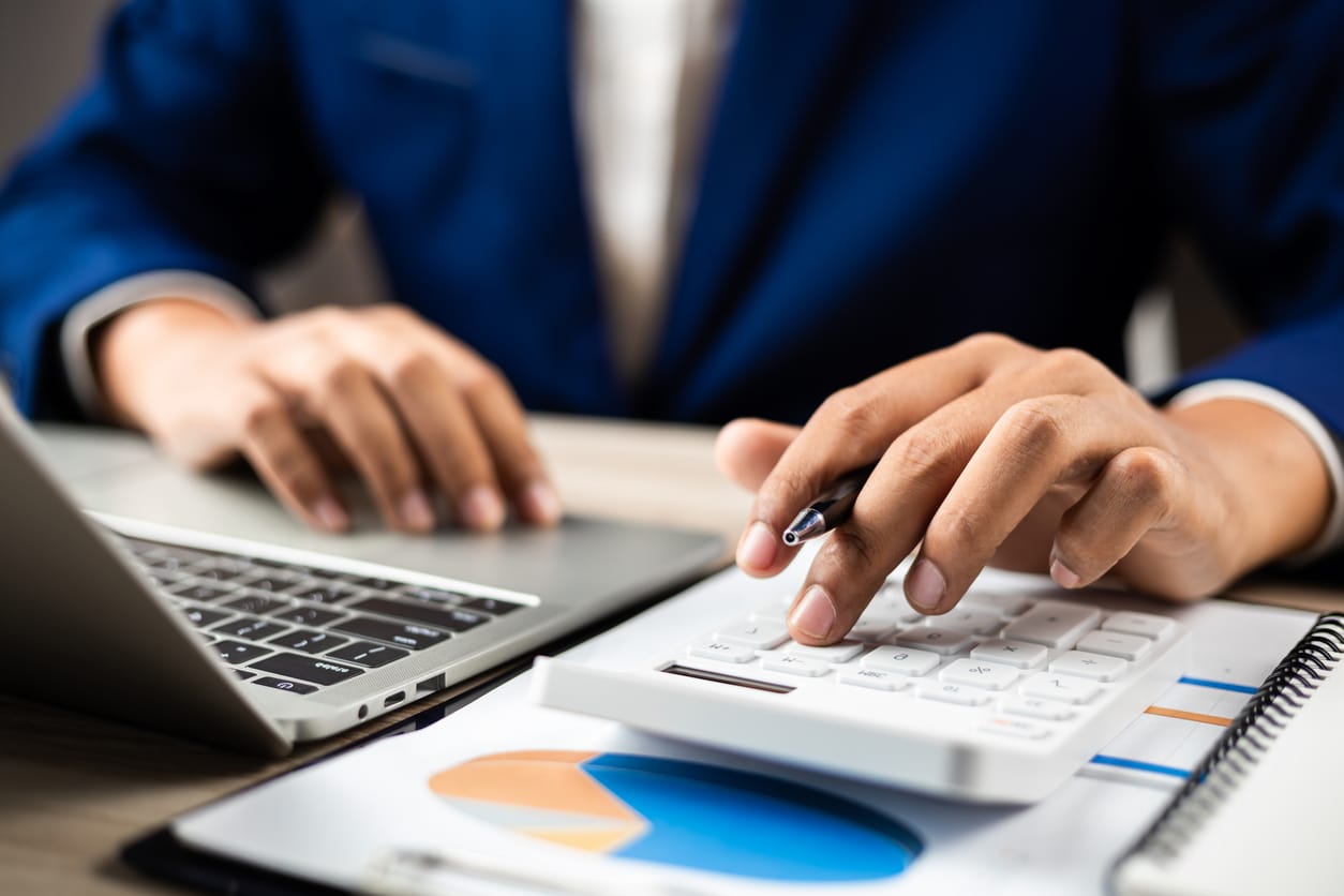 Business finance and budget management: Businessman using calculator and analyzing documents to manage company finances