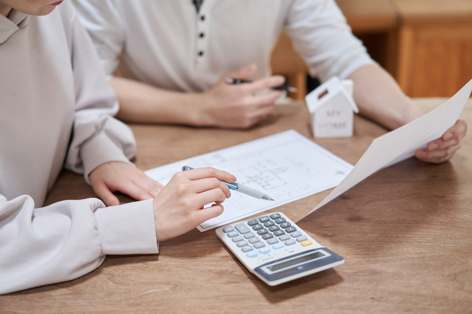 A couple discussing cost control with paper and calculator