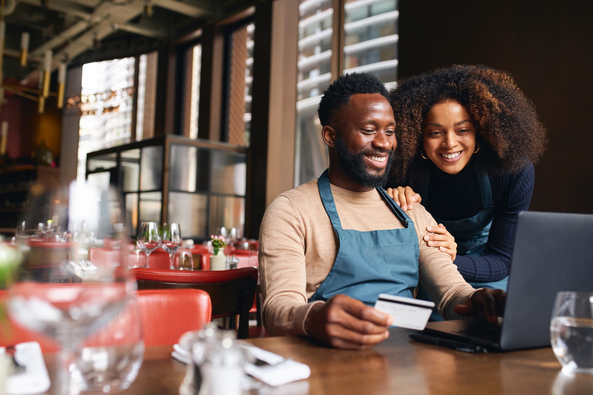 Restaurant owners using credit card online to pay bills on time and raise credit score