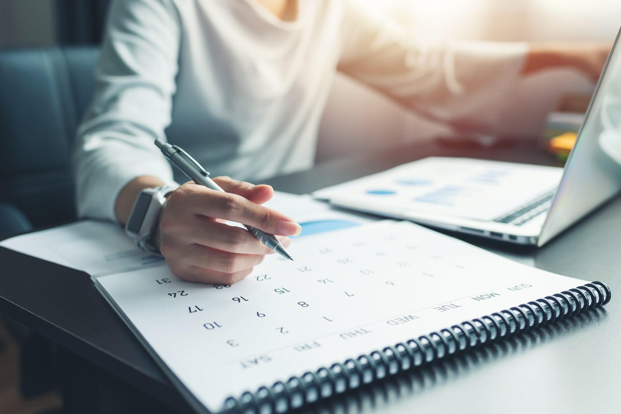 Business woman sitting working and thinking to planner with calendar and laptop