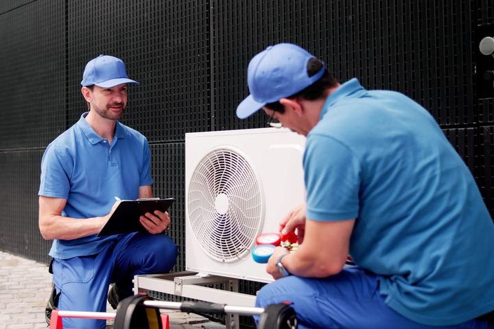 Hispanic Electrician Inspects Commercial AC Unit For Maintenance And Repair