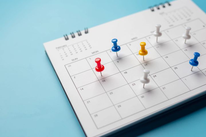 Calendar on solid blue background with copy space, pinned on a calender on date to show schedule, planning, and checklist concept