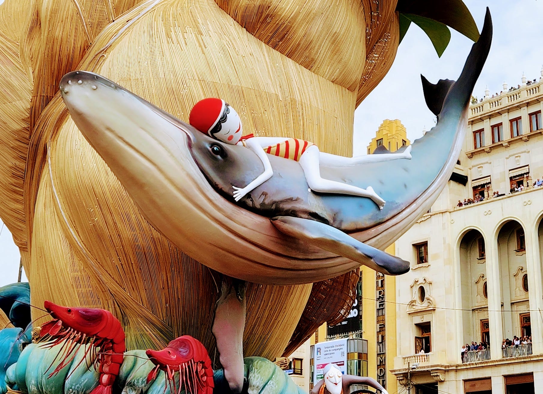 Detail from a photo of a sculpture showing a girl in a bathing suit rising on the back of a whale