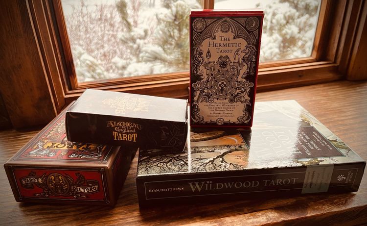 Four decks of tarot cards: the Tarot Del Toro, Alchemy of England Tarot, the Hermetic Tarot, and the Wildwood Tarot.