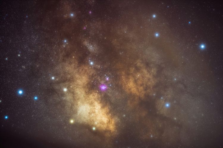 Masses of bright gold and black substances, dotted with closer stars that mostly look blue or yellow, but there's a pink one at the very center.