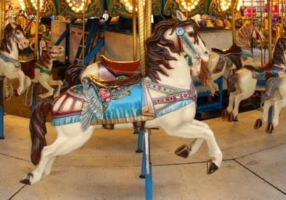 Photograph of a white carousel horse.