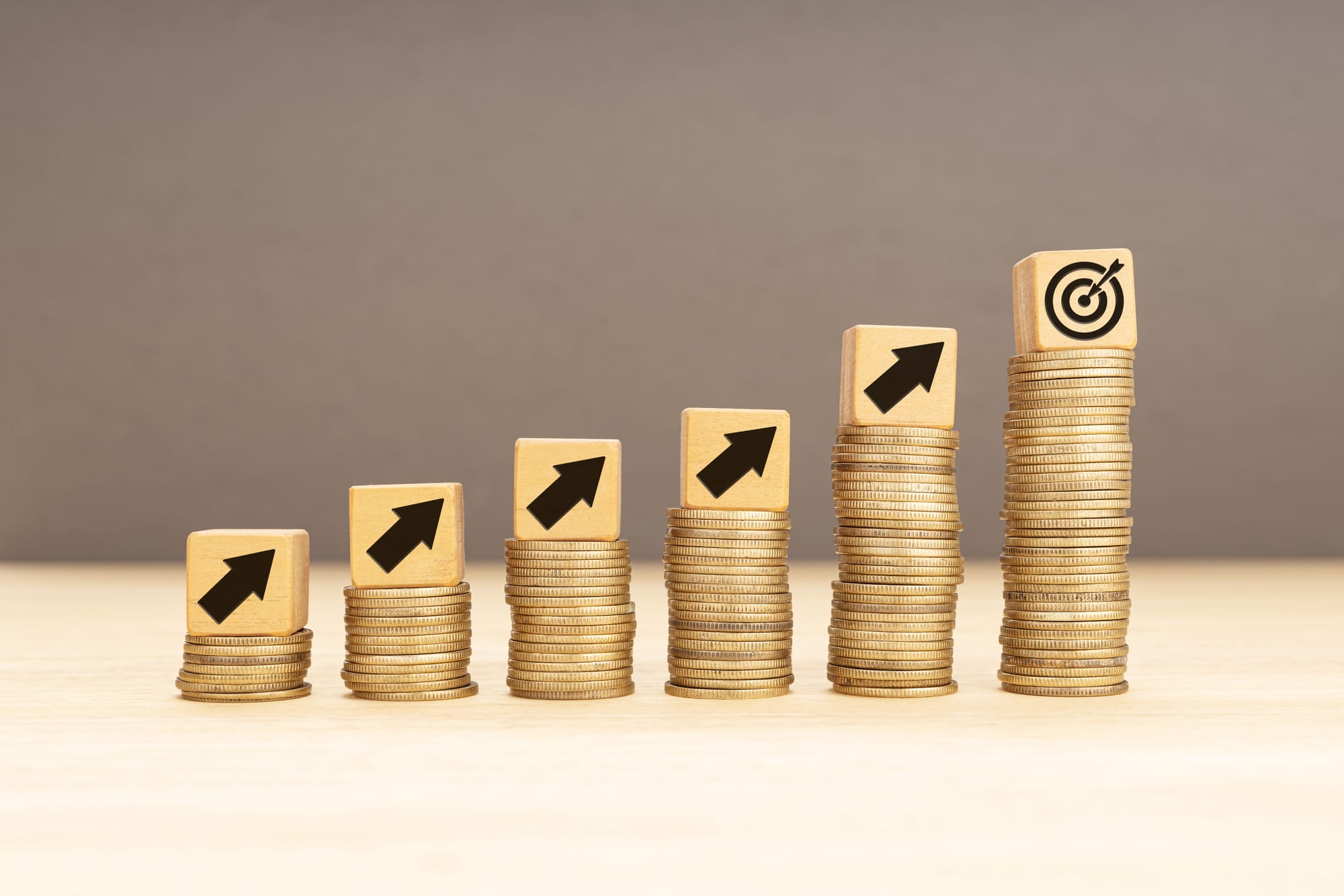 Stacked gold coins leading to a target