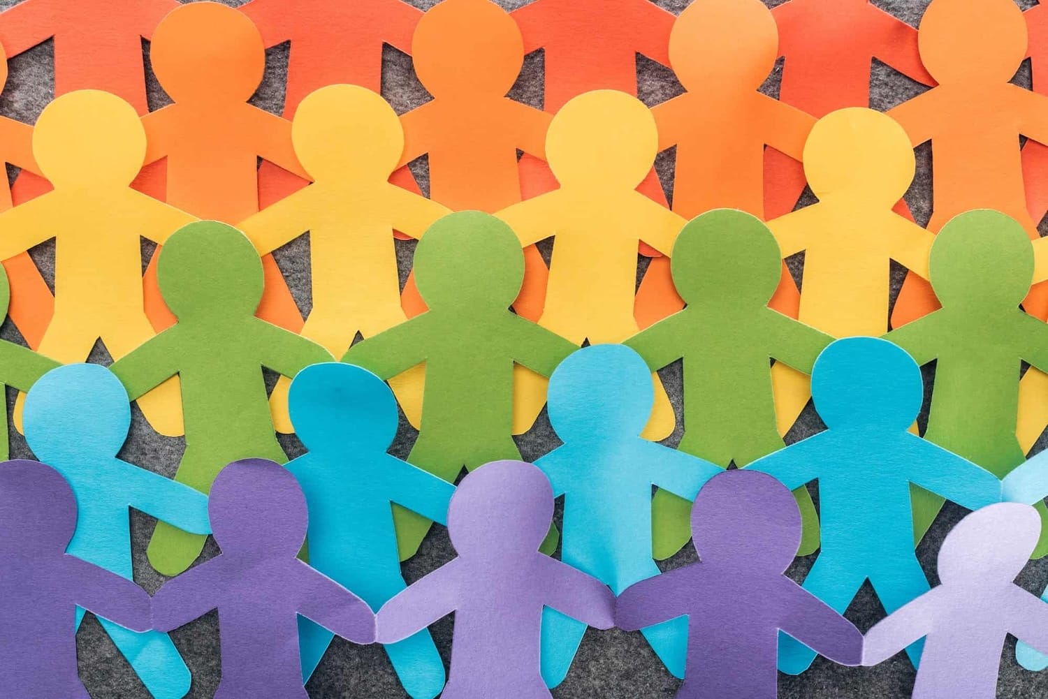 rainbow paper cut outs of people holding hands