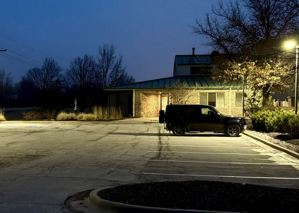 A single vehicle parked outside a quiet building at night, capturing the reflective moments when leaders begin to recognize patterns in their own actions
