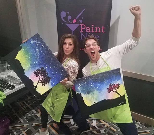 Couple with their finished Paint Nite paintings