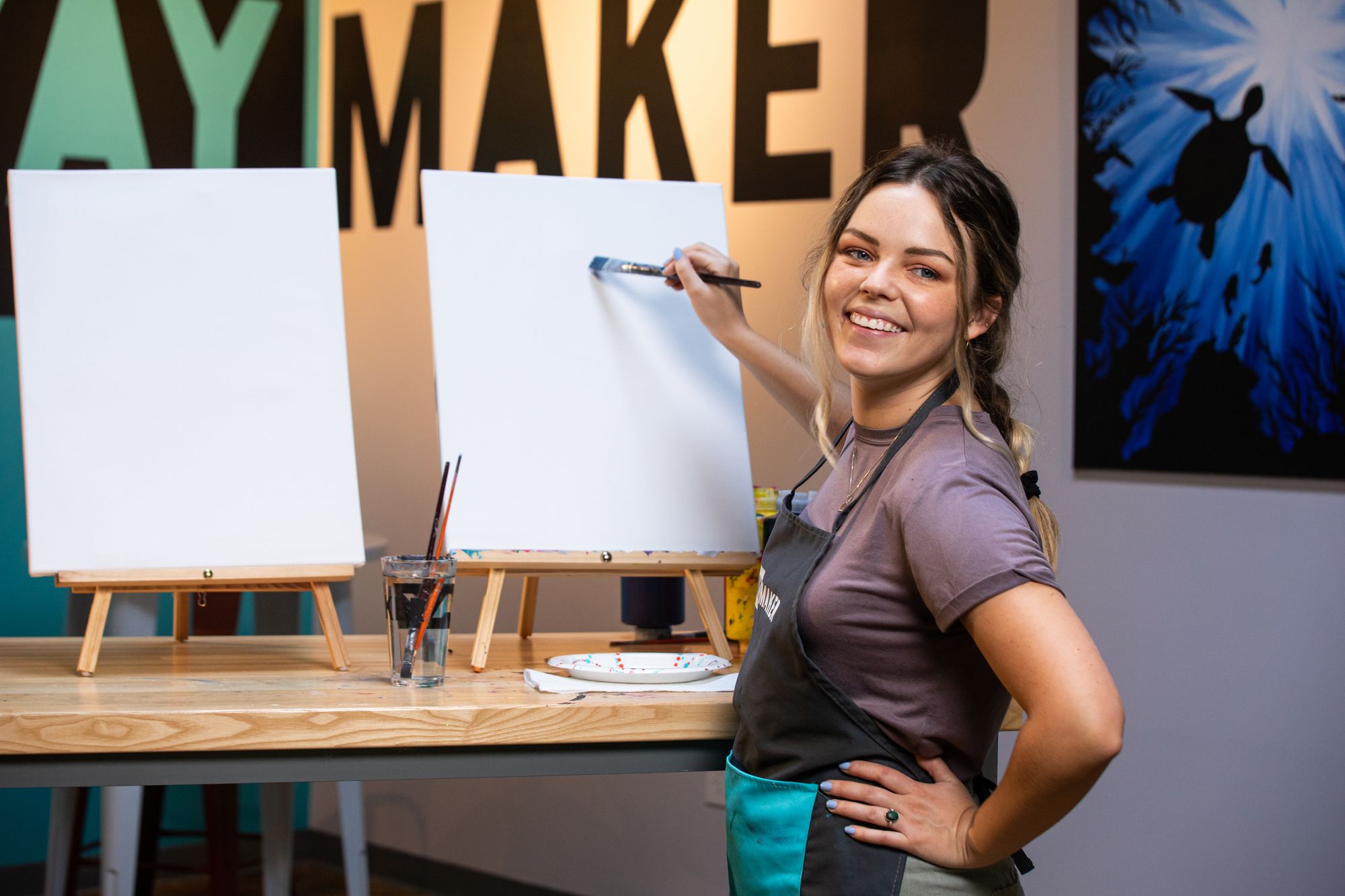 PaintNite.com host with two canvases for couple's paint and sip party