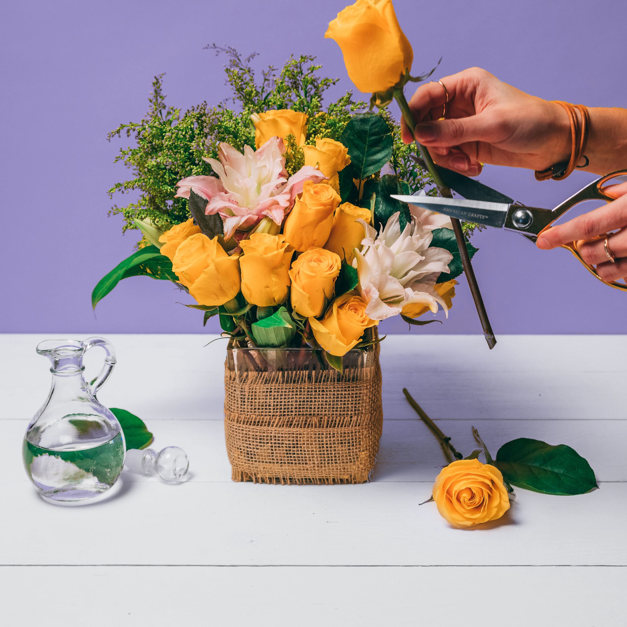 Hands trimming a rose for a bouquet