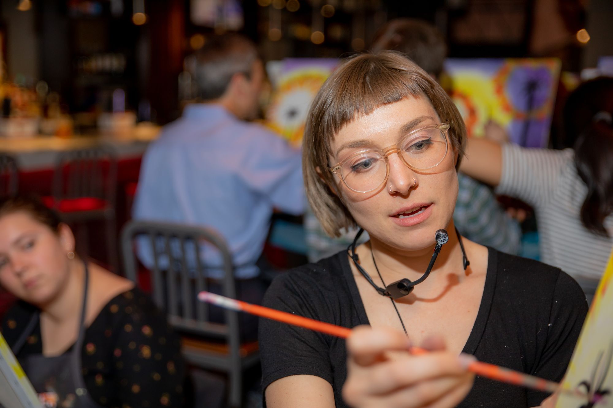 Paint Nite host leading a paint party in a bar