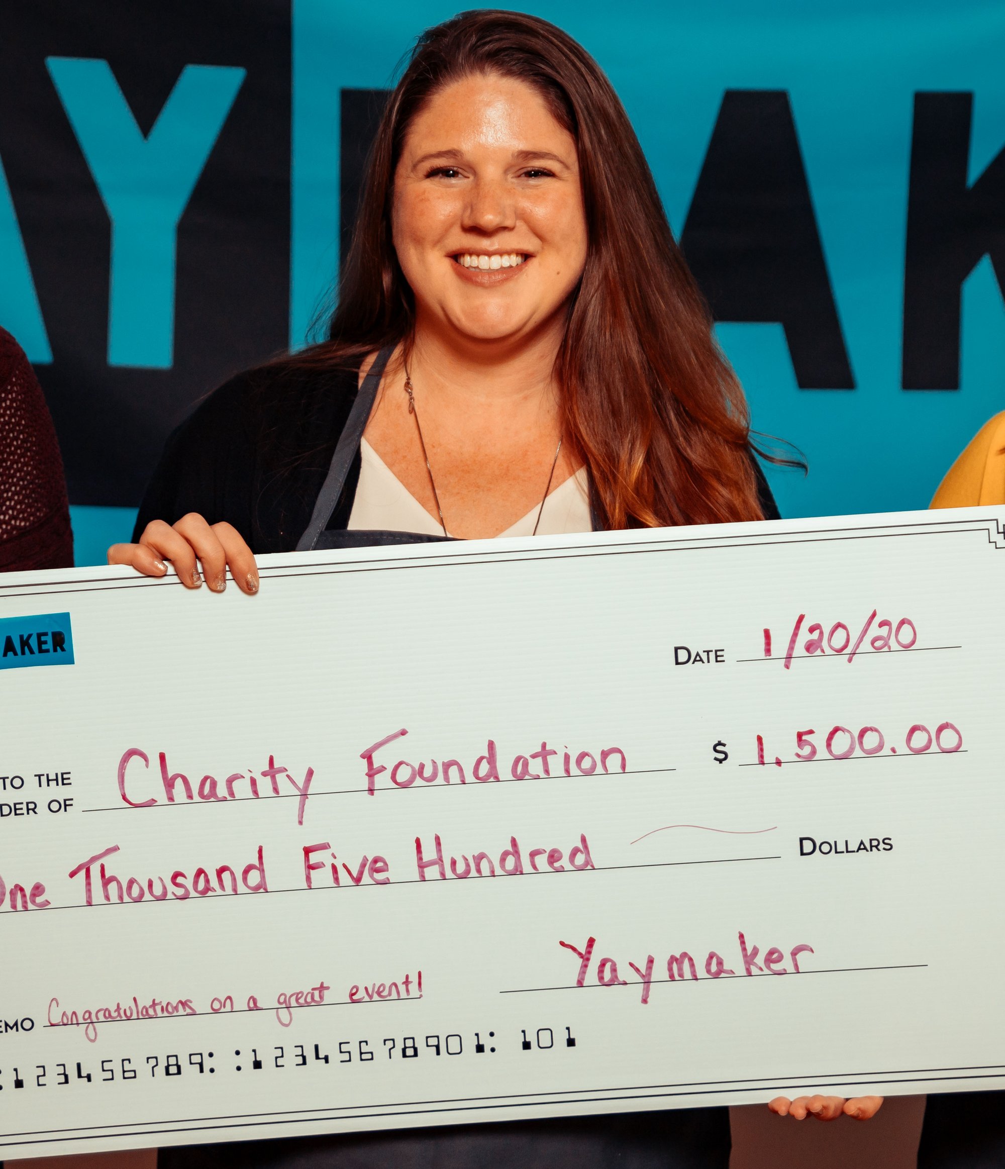 Lady holding a giant check following a fundraiser
