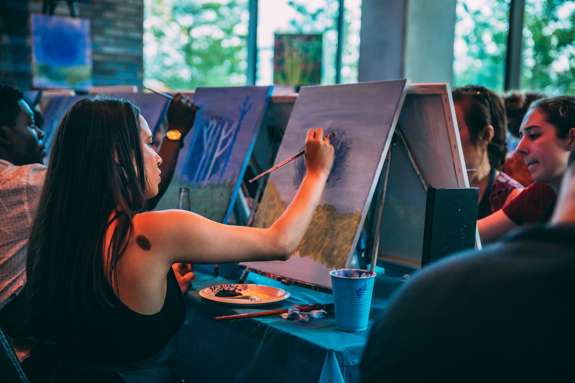 Group painting trees at a paint and sip with Paint Nite