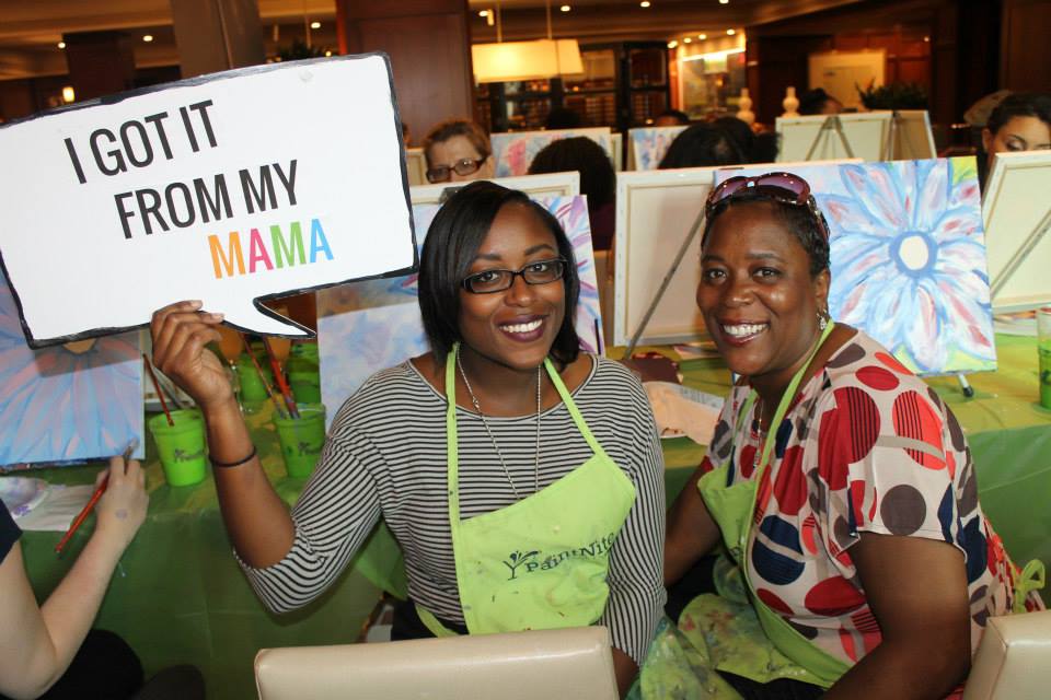 Daughter holding I got it from my mama sign with mom at Paint Nite