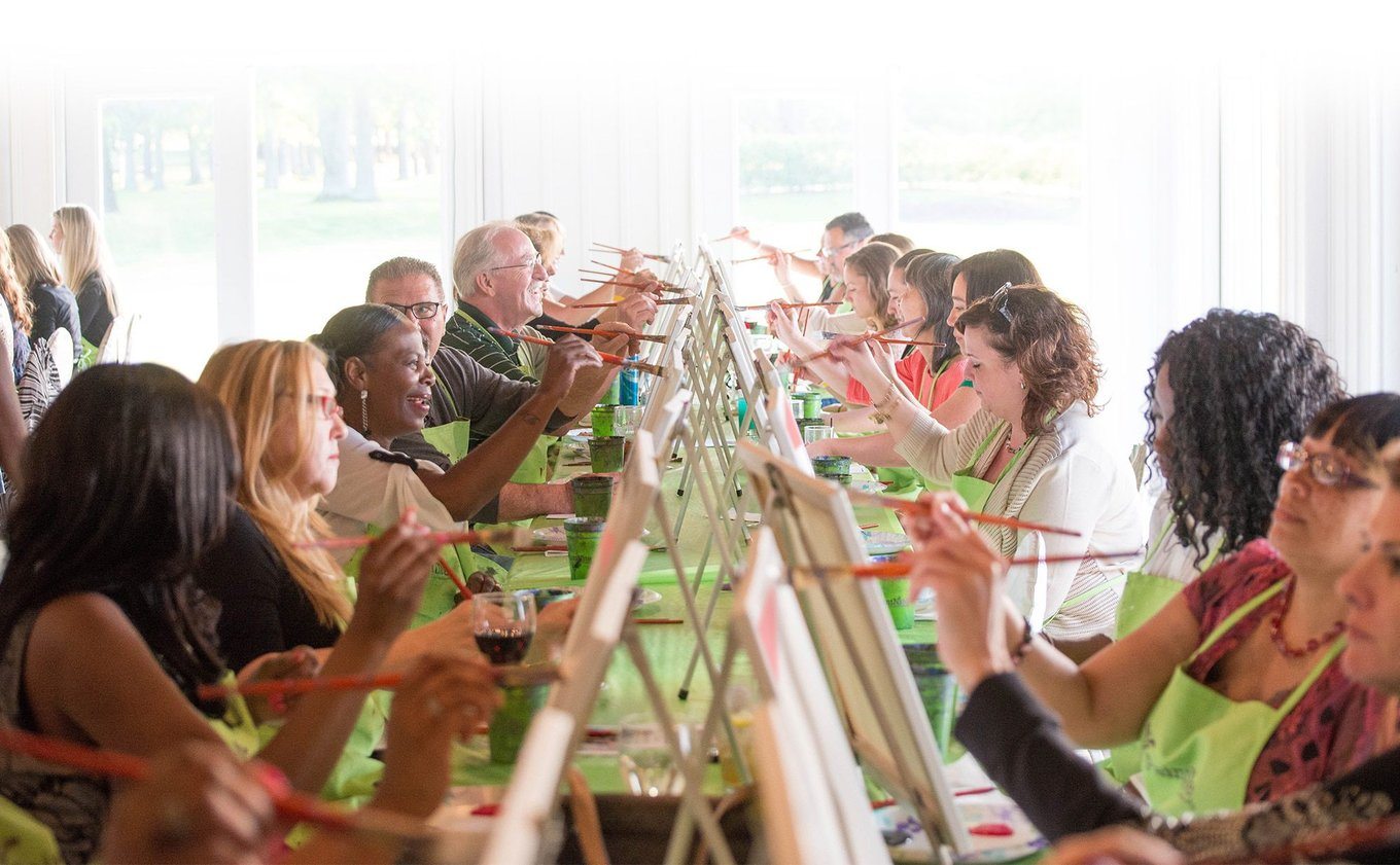 Group painting canvases at paint and sip event