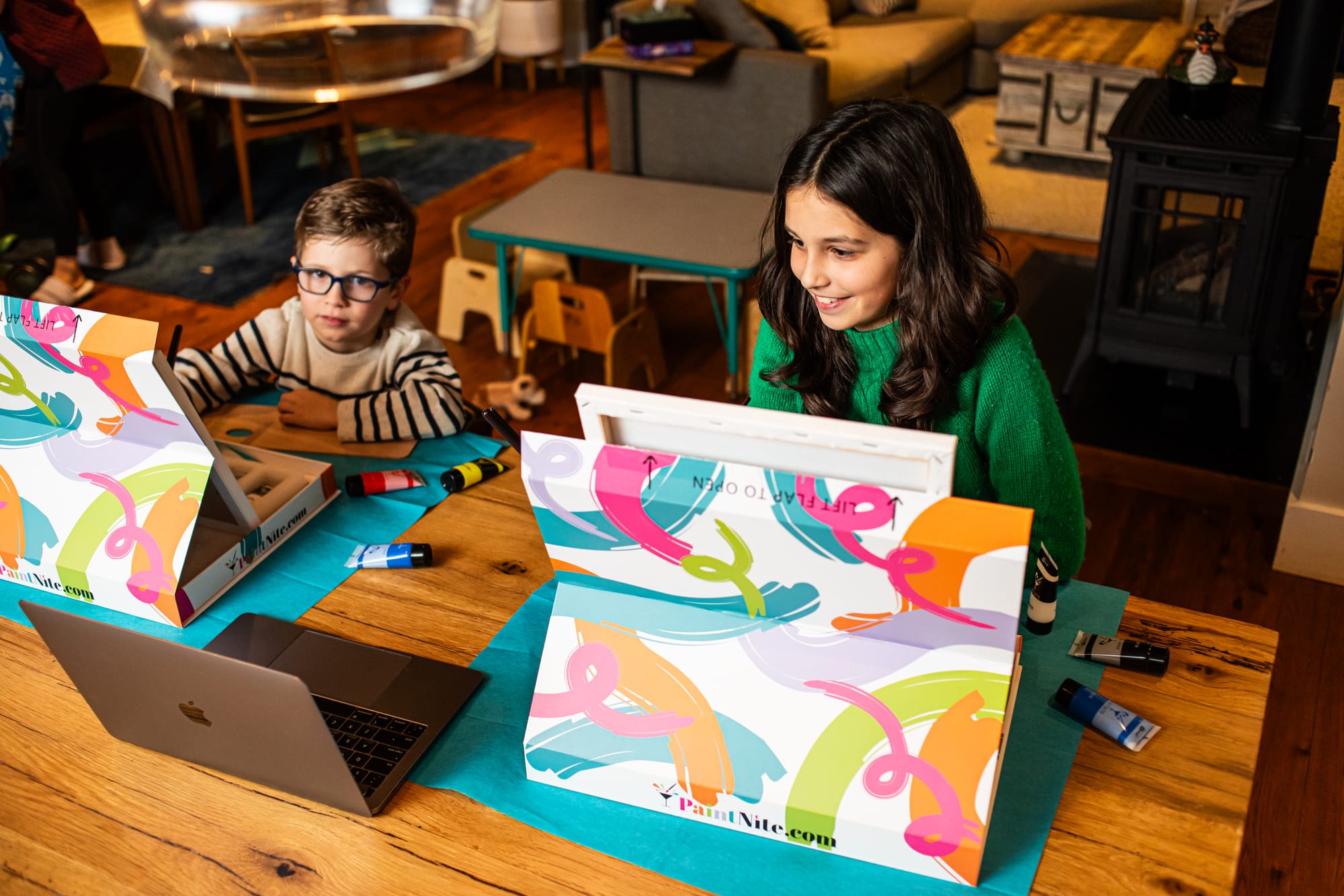 Boy and girl sat at kitchen table doing DIY paint and sip for kids