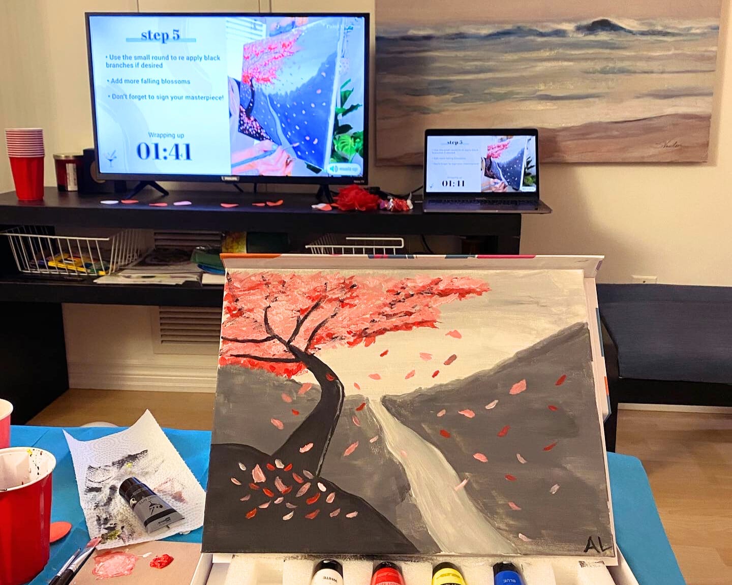 DIY paint night at home showing blossom painting and steps on screen