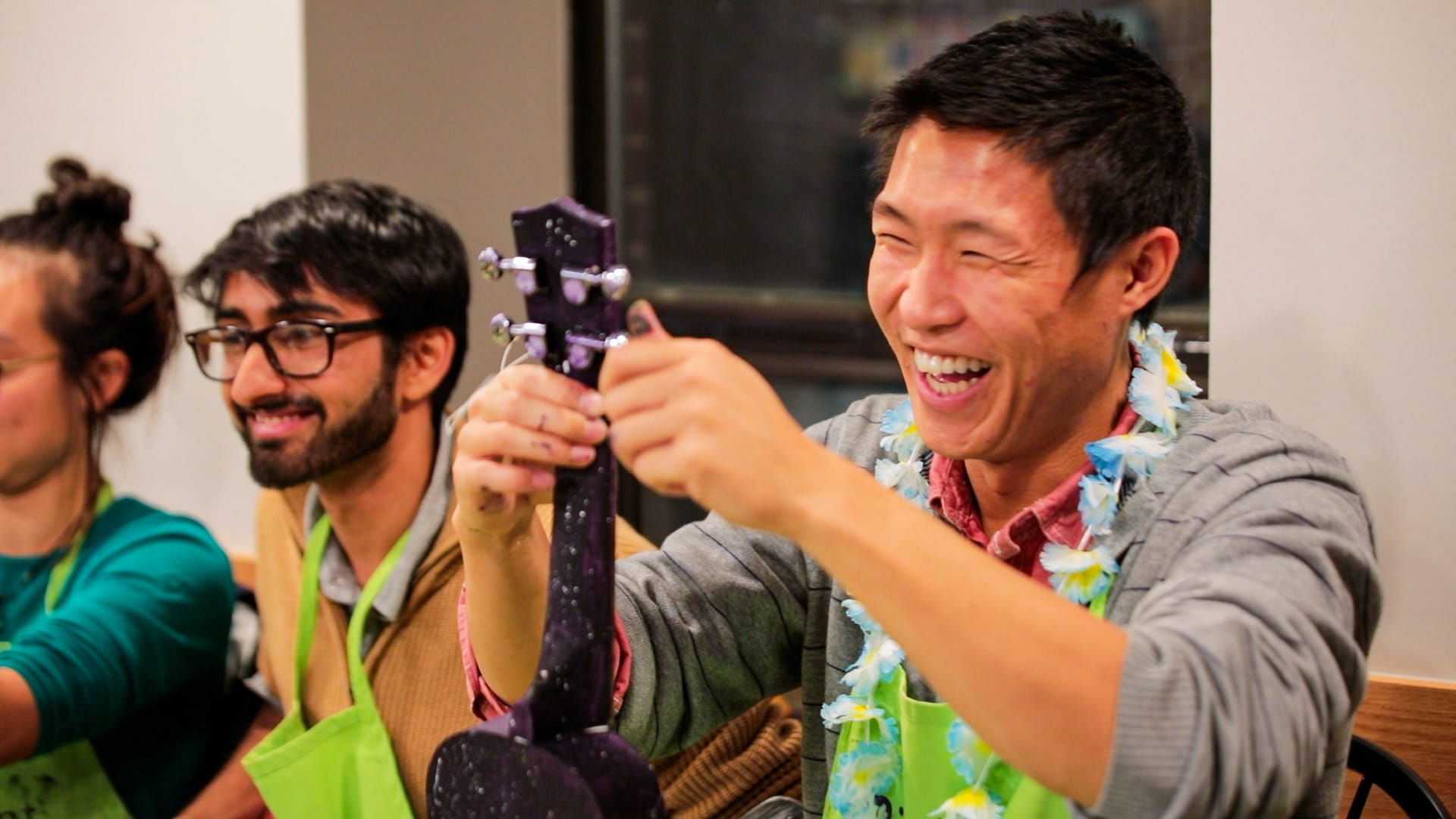Happy participant shows DIY ukulele made at creative money-making workshop