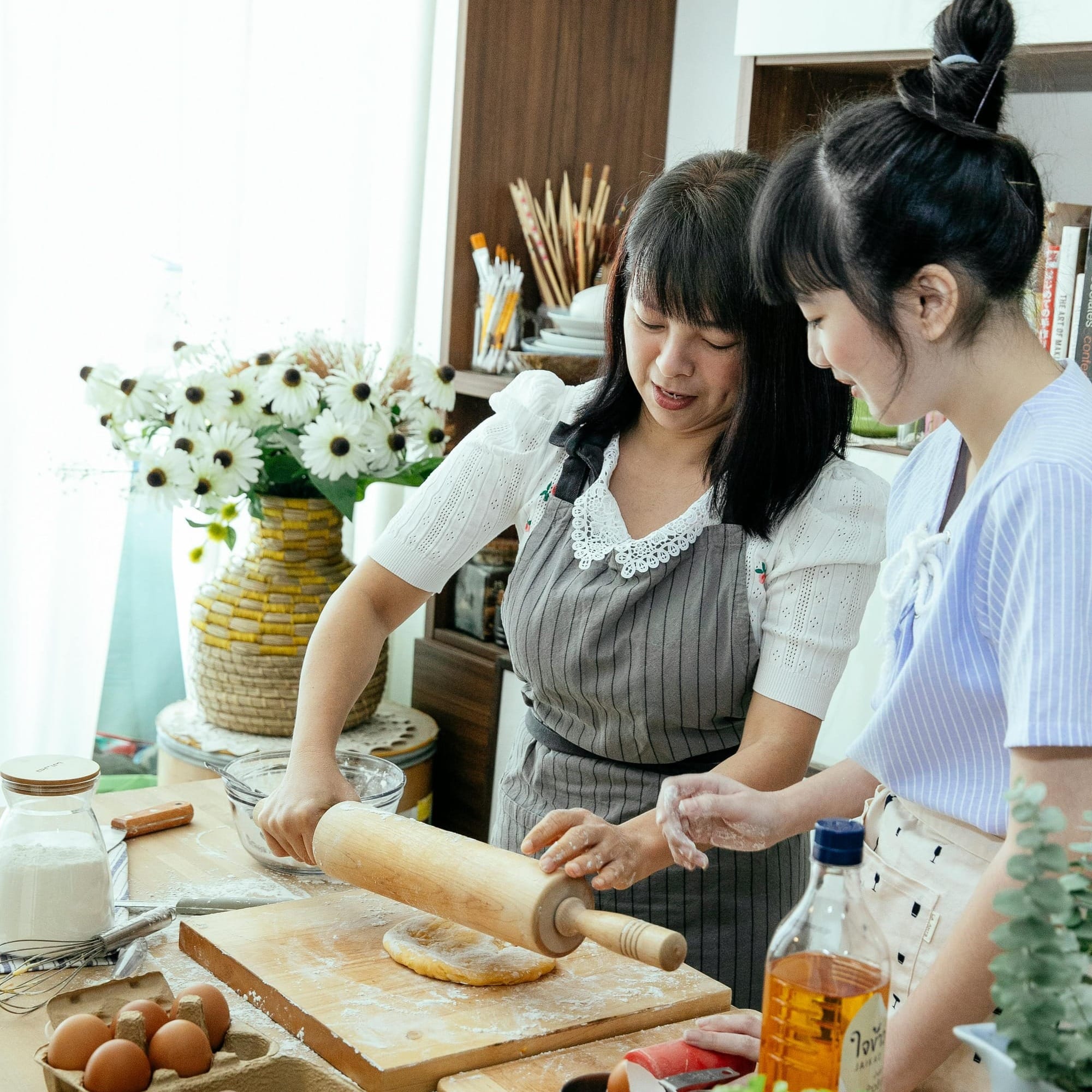 Two participants in a restaurant cooking class date night, preparing dough together in a commercial kitchen