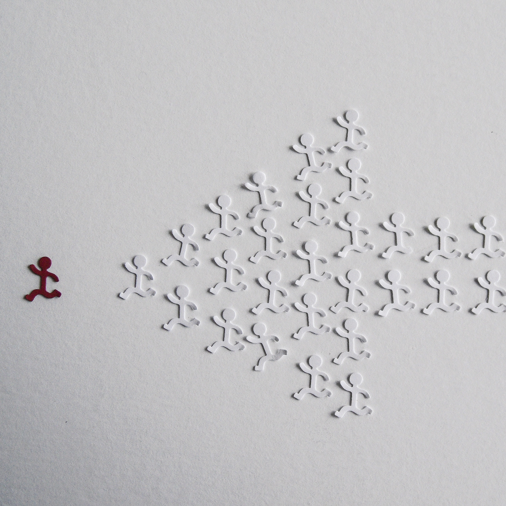 Graphic of a group of white stick figures running behind one red stick figure; arranged in the shape of an arrow