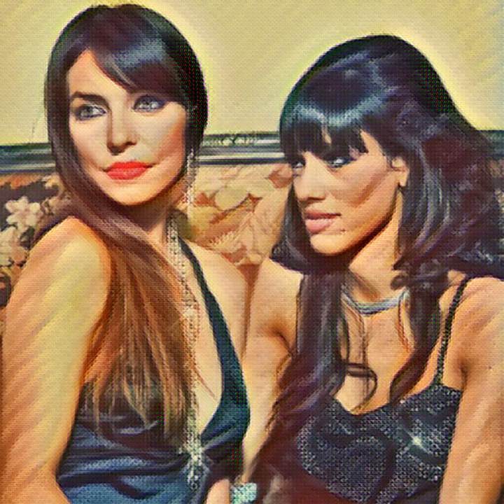 Two women dressed in black; one woman is looking at the other's profile