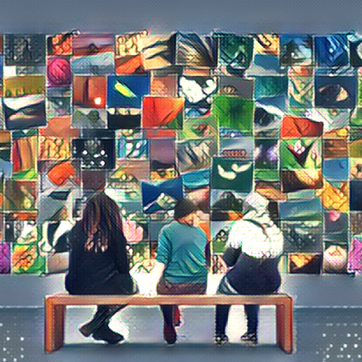 Three people sitting on a bench  in an art gallery looking at photos.