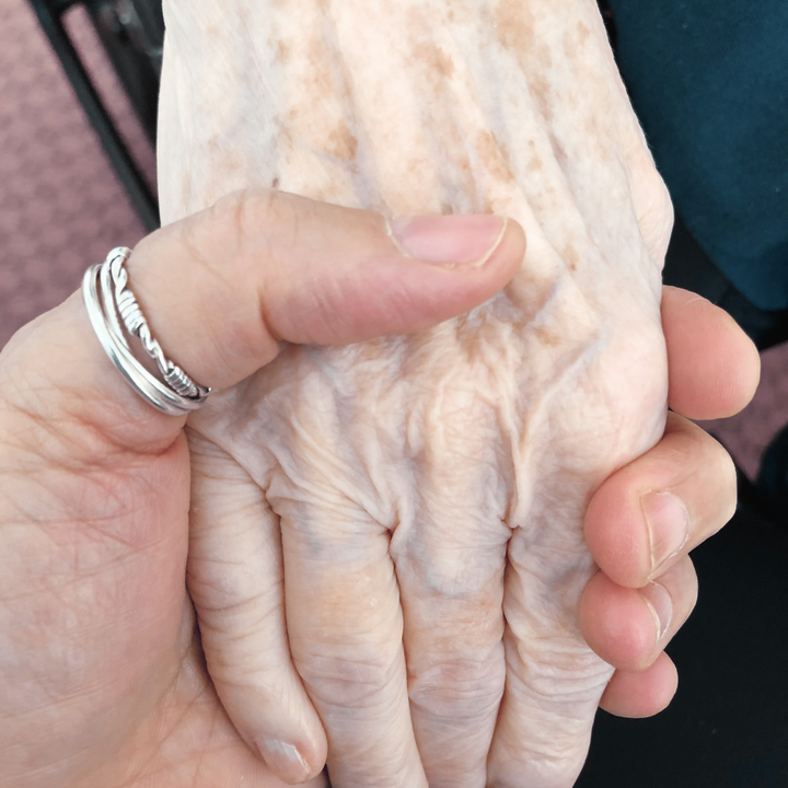 closeup of two people's hands clasped together
