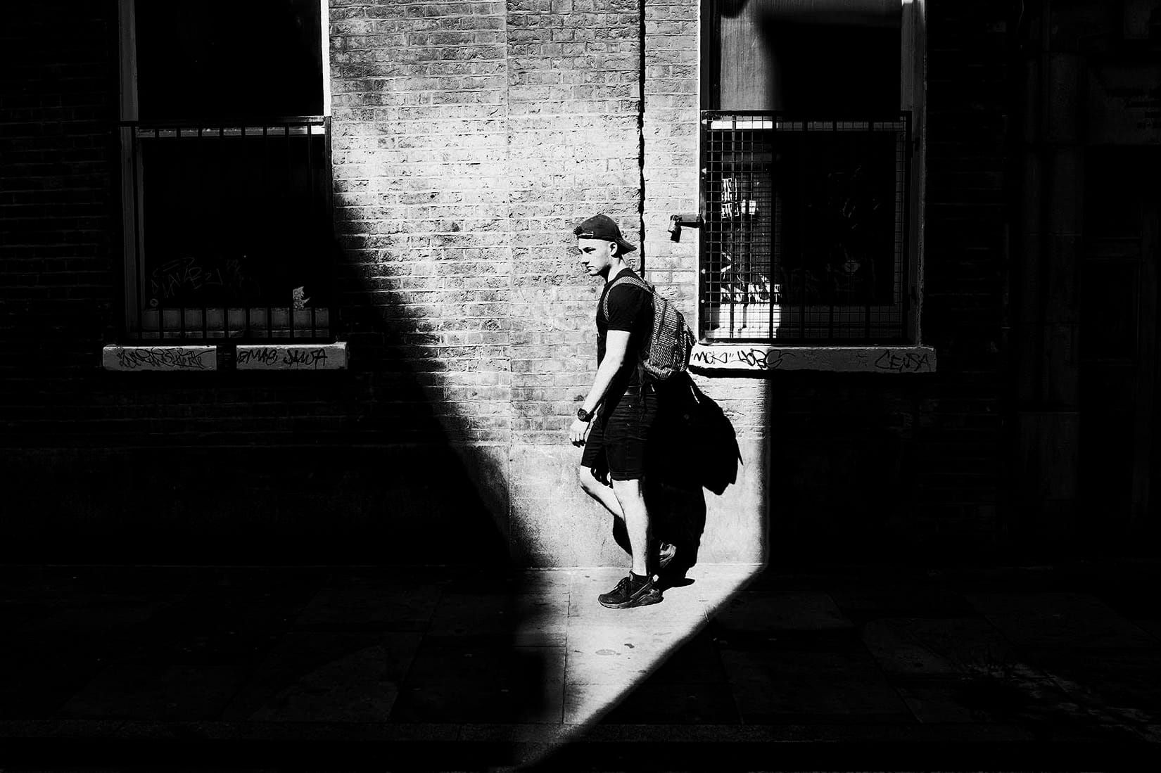 Black & White image of man caught in shadow light