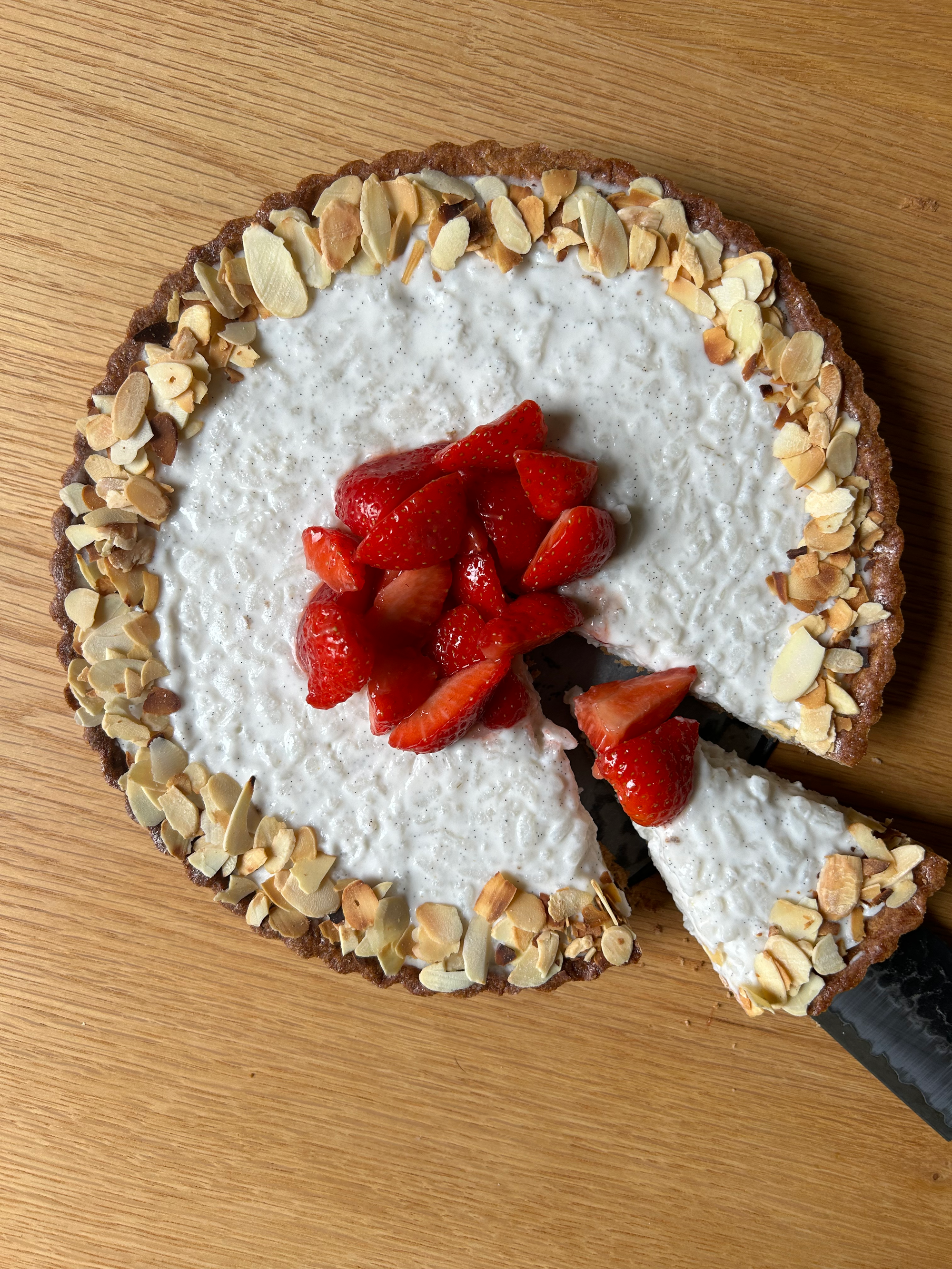 Rice pudding tart with macerated strawberries and toasted almonds