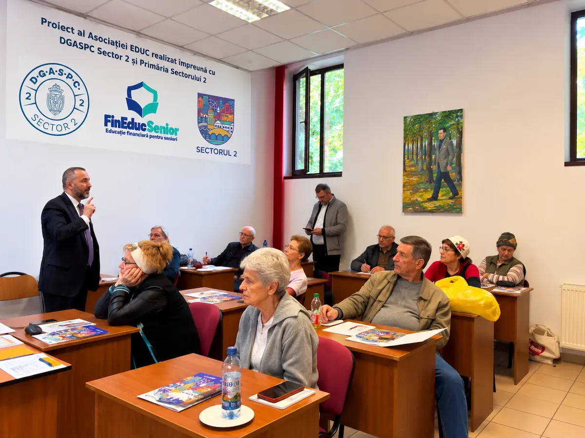 Seniori participând la o sesiune de educație financiară FinEduc Senior, într-o sală de curs
