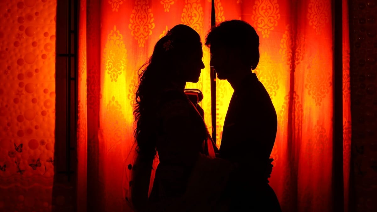 Silhouette di due persone che si avvicinano con delicatezza, immerse in un’atmosfera calda e rispettosa.