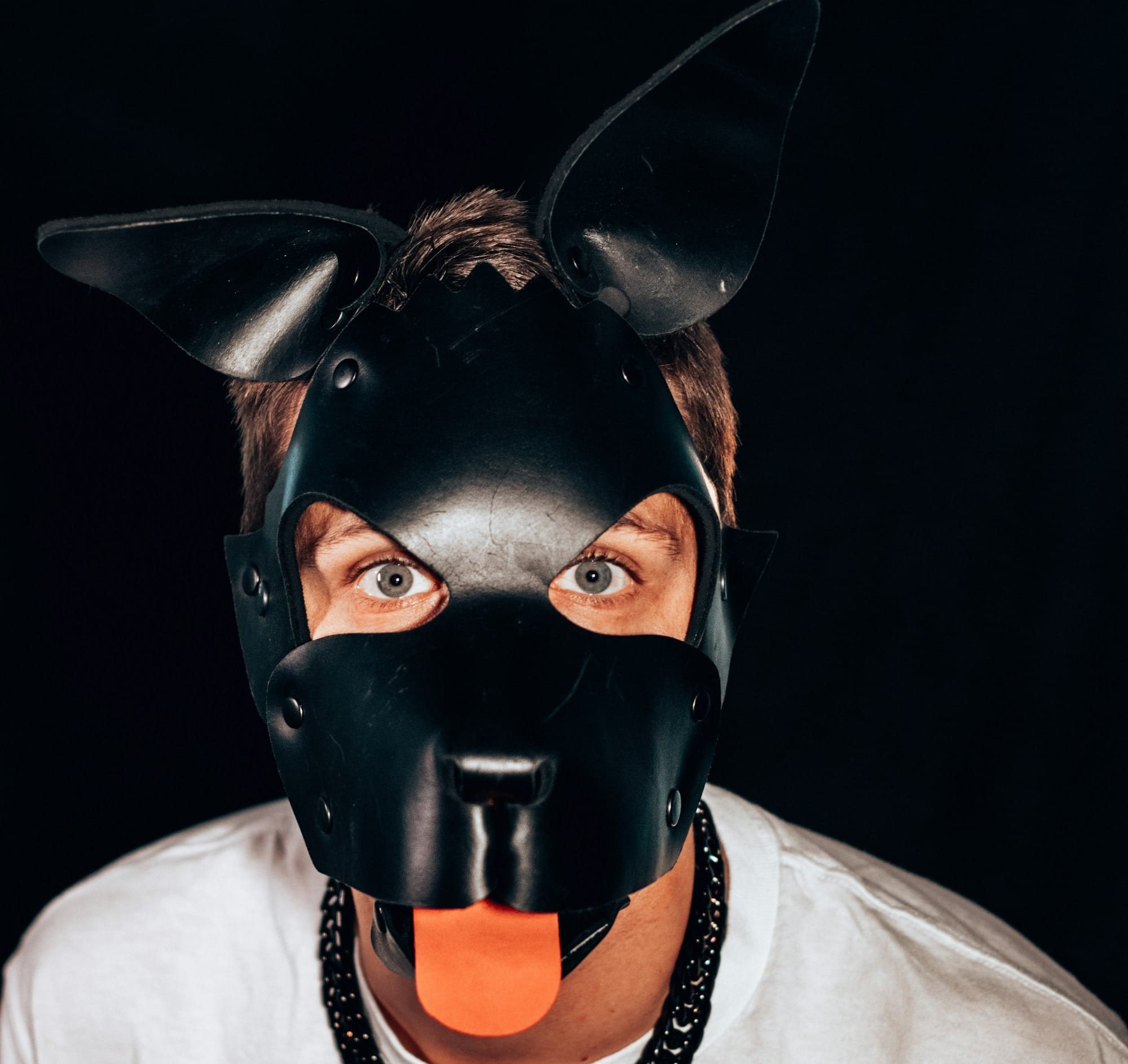 A man wearing a black mask with an orange tongue